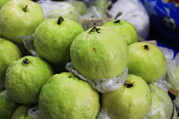 Fresh and green Guava fruit on the street market.Closeup fresh Guava in Thailand local market. A pile of organic guava on banana leaf plate.Fresh guava from organic farm.Thailand Local and natural pop
