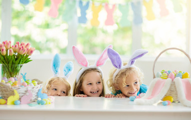 Kids on Easter egg hunt. Children dye eggs.