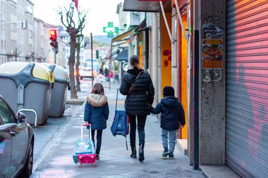 Madre con ni&ntilde;os de camino al colegio