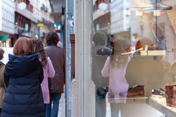Fototapeta na wymiar Reflejo de gente en escarapate en una calle comercial