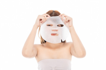 Young Asian girl with facial mask looking at camera over white background. Cosmetic procedure. Beauty spa and cosmetology.