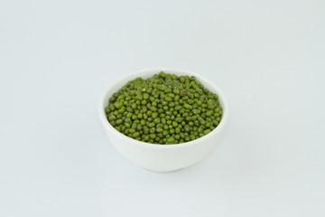 dry mung beans in white ceramic bowl on white background. protiens. for packaging. advertising. editorial