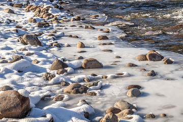 Ice on stones on a mountain river close-up