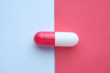Close up of single capsule on color background 