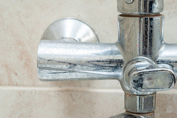 Dirty tap faucet in the bathroom in the plaque and stains from the water.