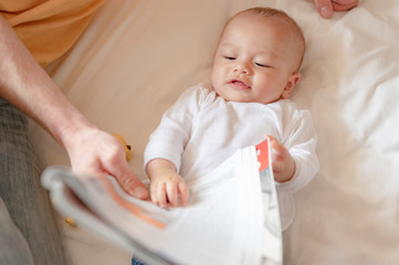 The baby lie leisurely and lull with parents in the living room at house. Family, Parent, son,...