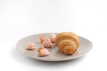 Croissant with decorated flowers in the grey plate horizontal view
