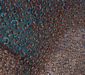 Pattern of randomly interwoven rings and balls of different diameters and turquoise, brown and...