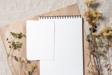 Wedding invitation mockup with dry plants , old papers on grey textile background. Top view, flat lay. Wedding stationary. Perfect for presentation of your invitation, menu, greeting cards