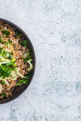 Russian, Ukrainian traditional cooked buckwheat grain porridge in bowl with parsley, herbs, onion, butter. Vegan vegetarian diet food. Homemade