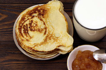 Pancakes with honey on a wooden table. Glass of milk. Healthy food. Breakfast. 