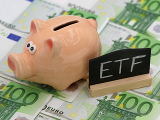 piggy bank and blackboard which shows ETF on hundred euro banknotes, concept of exchange-traded...
