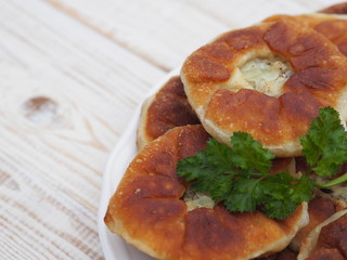 Belyasha homemade baking with meat on a white rustic wooden table.