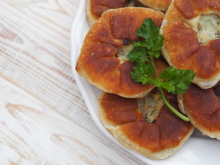 Belyasha homemade baking with meat on a white rustic wooden table.