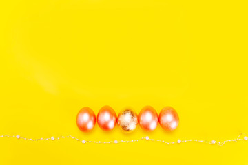 Trendy minimalistic concept of easter holiday with pearl colored eggs over bright yellow