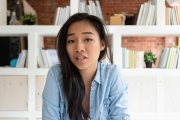 Head shot portrait Asian online teacher woman speaking by webcam