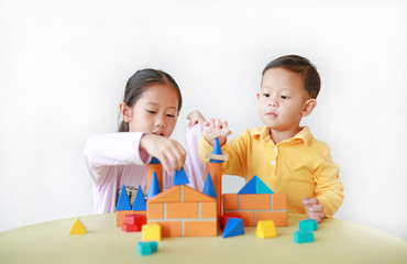 Asian sister and her little brother playing wood block toy together. Little Boy and girl doing...