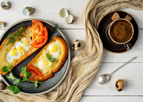Breakfast or lunch toasts (bruschetta) with vegetables and fried quail eggs on white wooden table, nearby cup of coffee espresso. Dieting food concept antipasti. View from above.