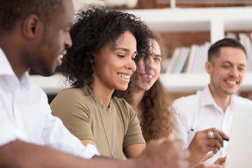 Happy diverse employees team working on project together close up