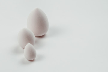 Small, medium and large  white beauty blender isolated.