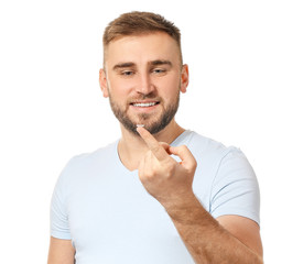 Young man with contact lens on white background