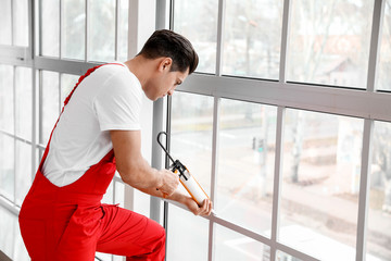 Male worker installing window in flat