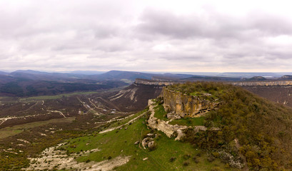 Fototapeta premium Tepe-Kermen cave city, near the city of Bakhchisaray, Crimea. Panoramic aerial drone view