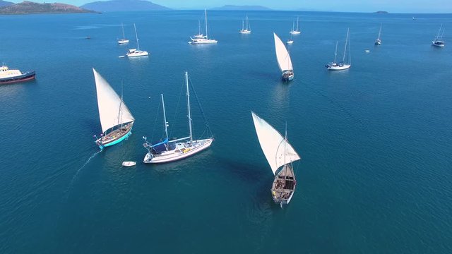 Traditional Pirogue Boat Sailing out of Anchorage in Madagascar. Aerial Shot of Wooden Boat with Sail Up.