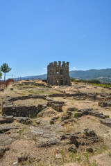 View at the exterior front facade of medieval Saint Cornélio tower, woman looking the building, iconic ruins monument building at the Belmonte village, portuguese patrimony