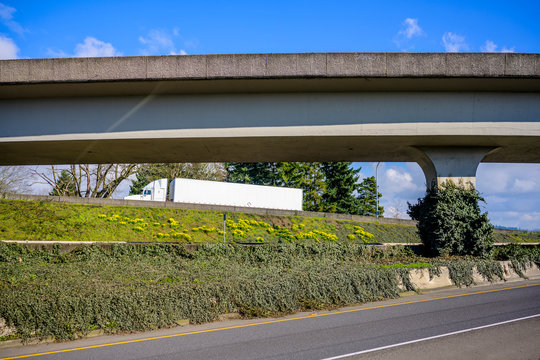 Big Rig Semi Truck Transporting Cargo In Dry Van Semi Trailer Running Up On The Concrete Overpass Road Intersection