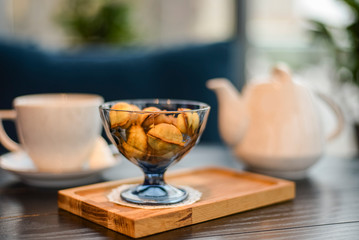 Russian walnut cookies stuffed with condensed milk in glass bowl in a restaurant with blurred background.