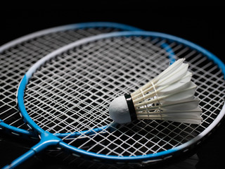 Badminton shuttlecock and badminton racket in the black background used in competition