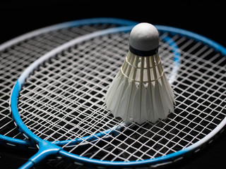 Badminton shuttlecock and badminton racket in the black background used in competition