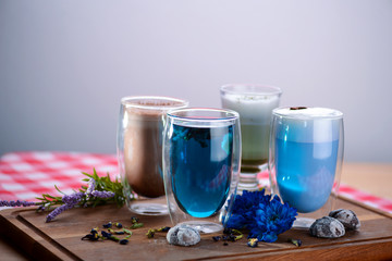 Top view of a cup of butterfly pea blue tea, pea flowers, blue pea for healthy drinking on dark wooden cutting board