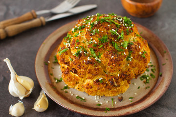 One whole roasted cauliflower head with seeds and parsley