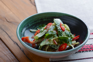 Healthy food. Ukrainian cuisine. Fresh green salad with cucumbers, pepper, parsley, dill and meat served on table.
