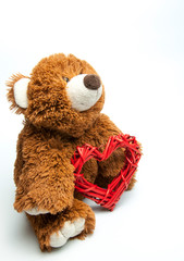 Cute teddy brown bear with a heart in his hands. Love. Gift and surprise. On white background