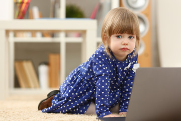 Cute little girl on floor carpet use laptop pc for chat with her dad away on business portrait. Point finger hand in display social web network bank mortgage credit wireless ip telephony concept