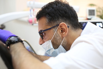 dentist is diagnosing the child while assistant in dental clinic