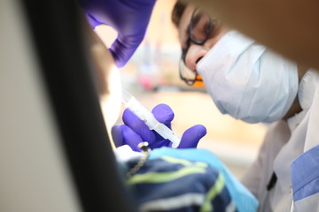 dentist is diagnosing the child while assistant  in dental clinic.
