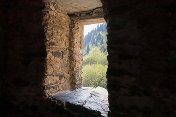 A window  inside a lonely riverbank at the foot of the mountains of the watchtower - Koshki - called the Tower of Love in Svaneti in the mountainous part of Georgia
