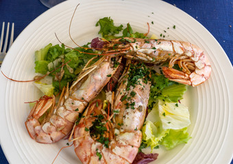 fried big shrimps with lettuce on white plate