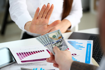 Male arm pay bunch of hundred dollars bills to office clerk closeup. Bribery accept backhander banknote venality laundering back scheme offshore company irs kickback collusion lobby gift compensation
