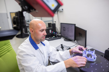 Quality engineer, scanning components by professional optical 3D scanner with a turntable, automotive concept