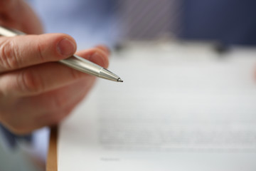 Male arm in suit offer contract form on clipboard pad and silver pen to sign closeup. Strike a bargain for profit white collar motivation union decision corporate sale insurance agent concept