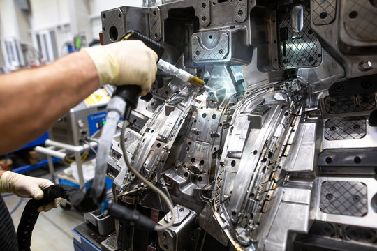 Engineer doing maintenance on the injection mold after production by dry nitrogen, industrial concept