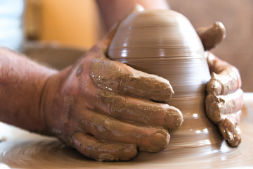 Working process of loam item in workshop. Man working in home studio. Craftsman at work.