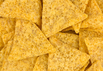 Tasty Mexican nachos chips as background, top view