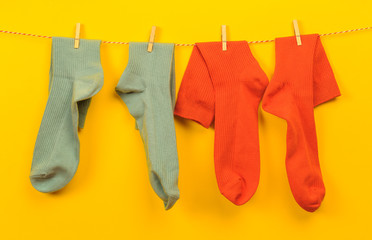 colorful   socks hanging on a rope on yellow  background - Image