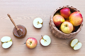 Top view of a handmade wicker basket of newspaper tubes with apples and a jar of honey on a wooden background. Traditional religious Apple Feast of the Saviour (Spas, Transfiguration). Still life